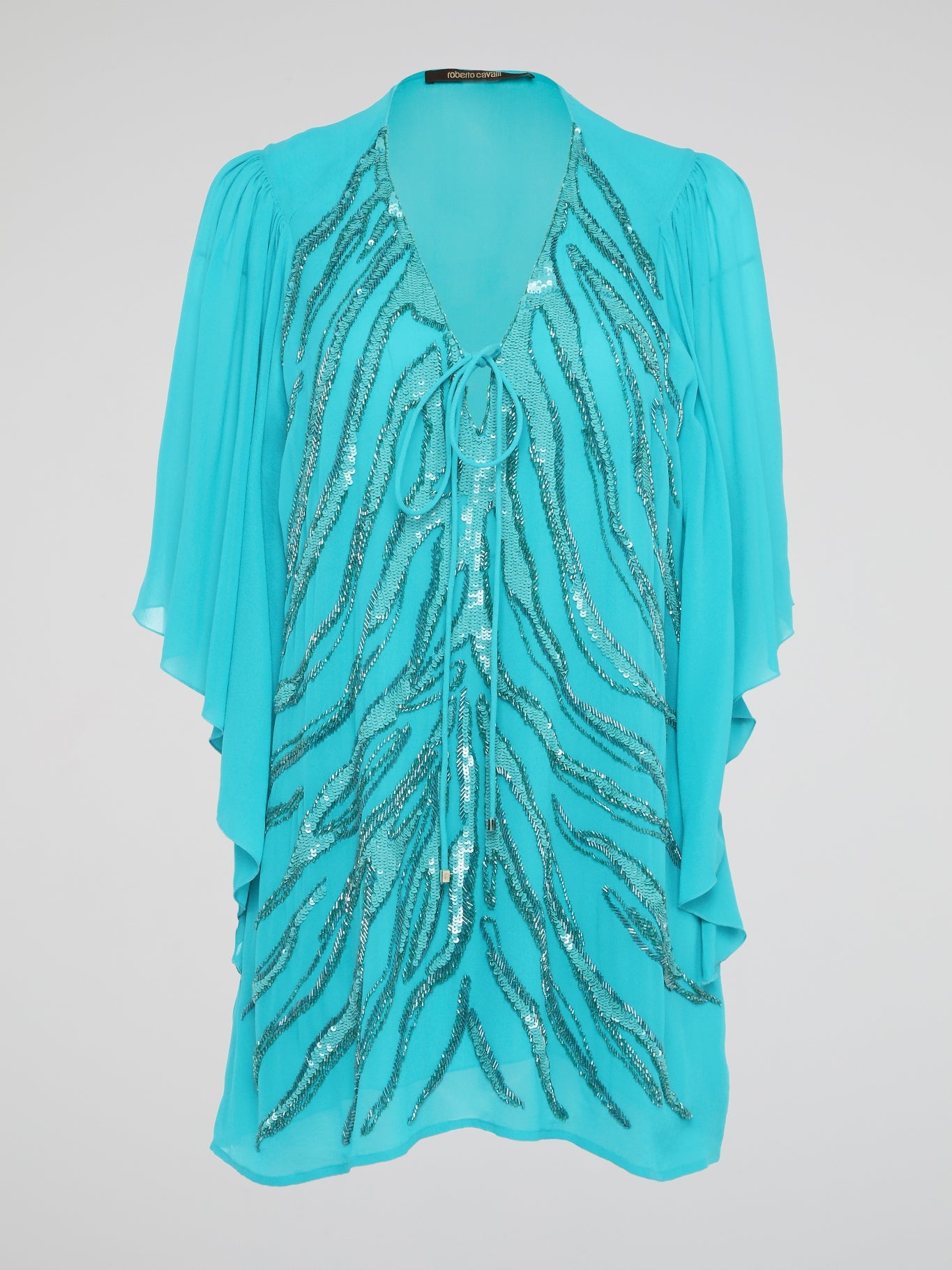 Shine like a star in the mesmerizing Blue Sequin Detailed Kaftan by Roberto Cavalli. This stunning piece features intricate sequin embellishments that capture the light and glimmer with every move you make. Perfect for a beach getaway or a special occasion, this kaftan exudes luxury and glamour, ensuring all eyes are on you wherever you go.