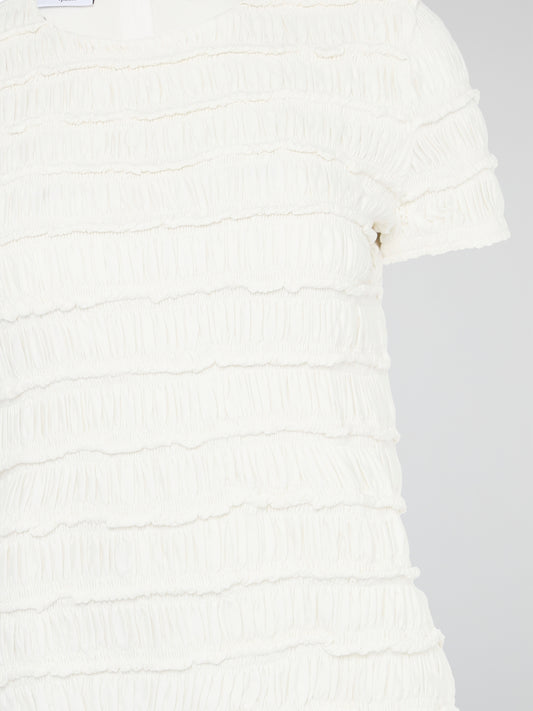 The White Tiered Top from Akris Punto is a captivating blend of sophistication and whimsy. With its unique tiered design, this versatile top adds a playful twist to any outfit. Made from premium materials, it effortlessly drapes to flatter your figure and is perfect for both casual and formal occasions.