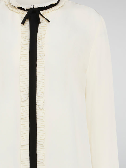 Step into luxury and sophistication with the Roberto Cavalli White Frill Detailed Blouse. The delicate frill detailing adds a touch of elegance to this classic white blouse, making it a perfect choice for any special occasion. Elevate your wardrobe with this timeless piece that exudes high-end fashion and style.
