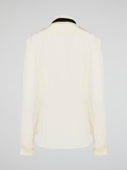 Step into luxury and sophistication with the Roberto Cavalli White Frill Detailed Blouse. The delicate frill detailing adds a touch of elegance to this classic white blouse, making it a perfect choice for any special occasion. Elevate your wardrobe with this timeless piece that exudes high-end fashion and style.